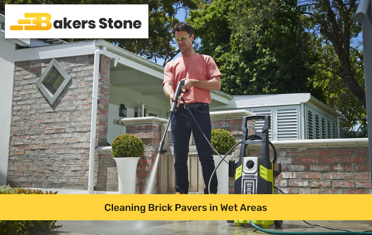 Person using a garden hose to rinse brick pavers