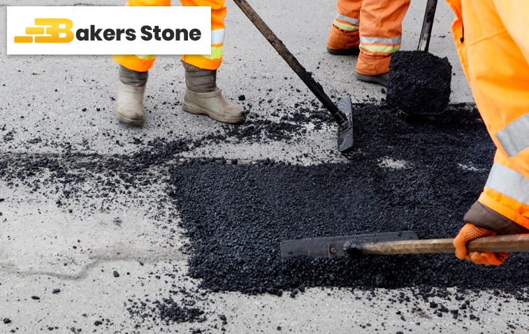 Workers repairing cracks in asphalt pavement on a road.